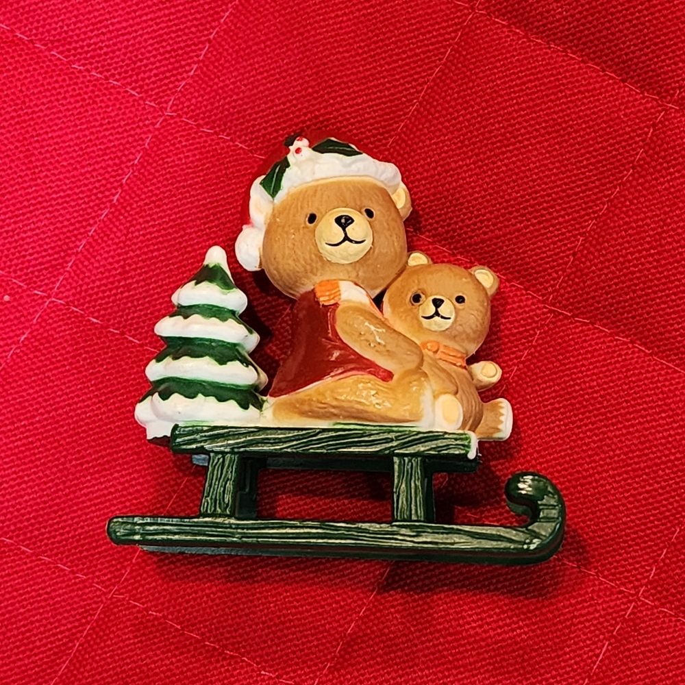 Christmas figurine featuring two teddy bears on a sled with a Christmas Tree